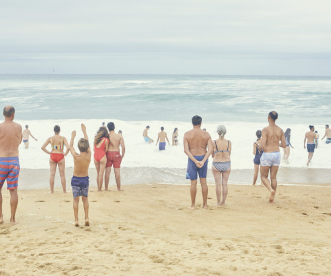 Zuschauer am Strand mit hohen Wellen
