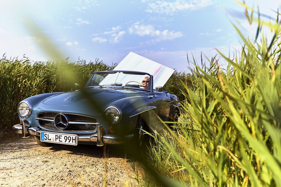 Malerin auf dem Rueckweg mit Gemaelde im Auto