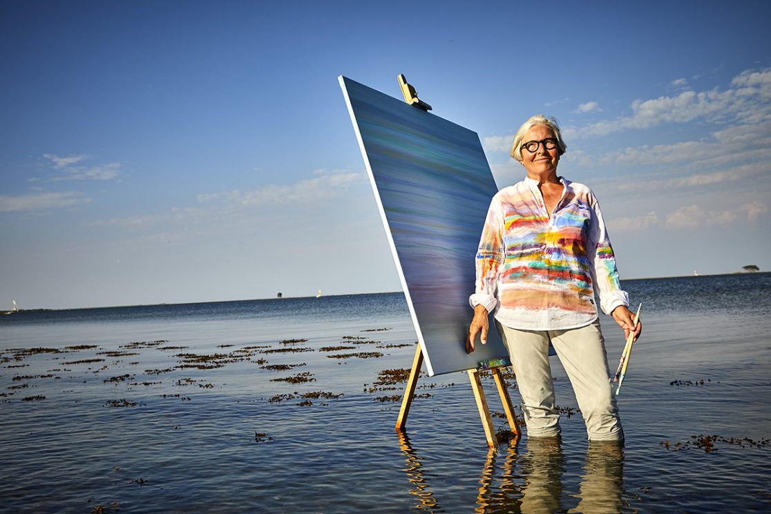 Malerin im Wasser mit Leinwand