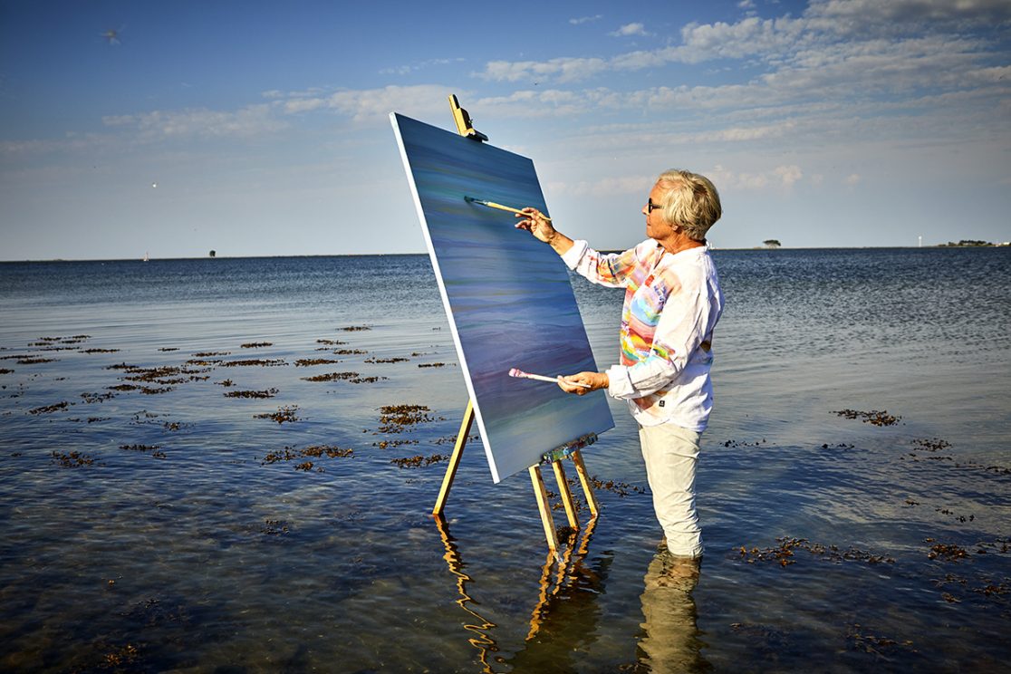 Malerin im Wasser mit Leinwand